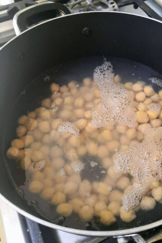 Large black pot filled with chickpeas covered completely in water