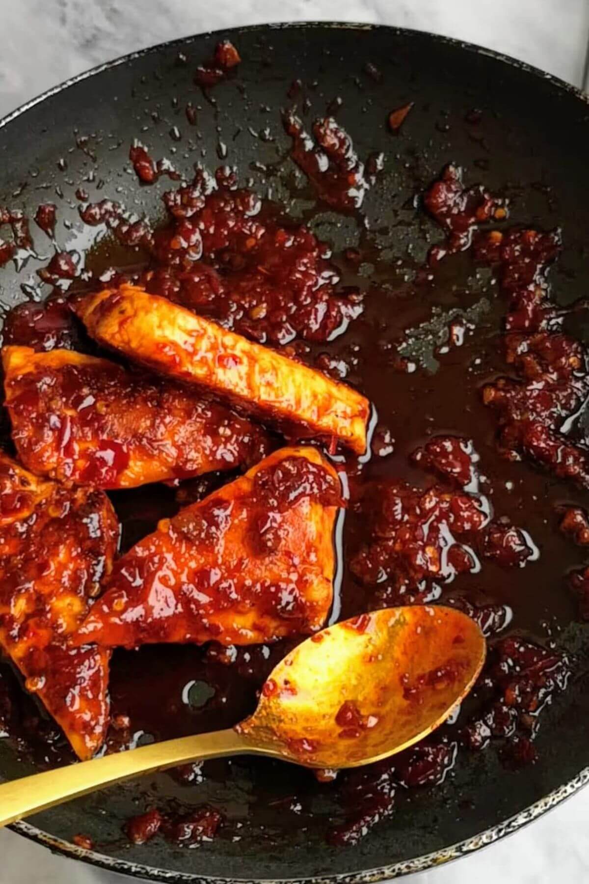 Halloumi triangles being mixed with honey and harissa sauce