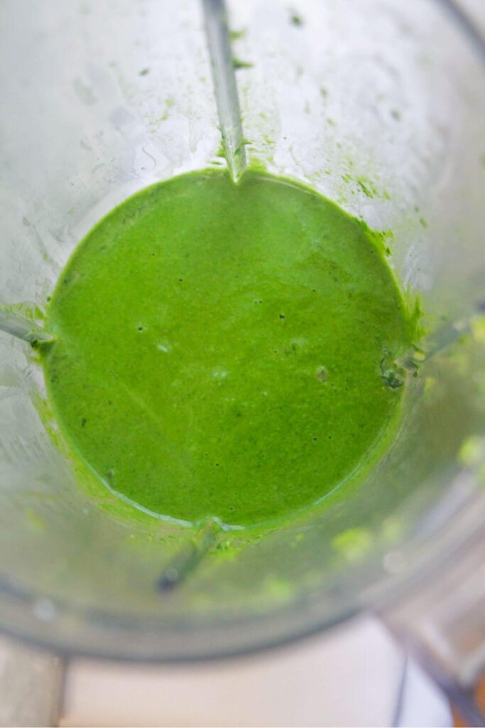 Smooth green pasta sauce in a blender after being blitzed.