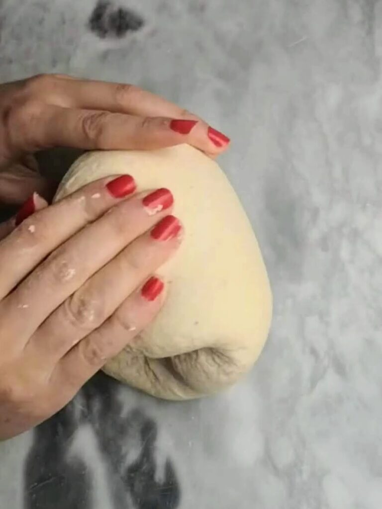 Hands folding the easy soft flatbread dough over on itself.