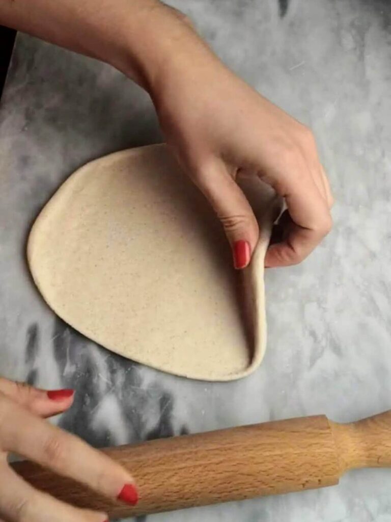 A hand picking up the easy soft flatbread circle.