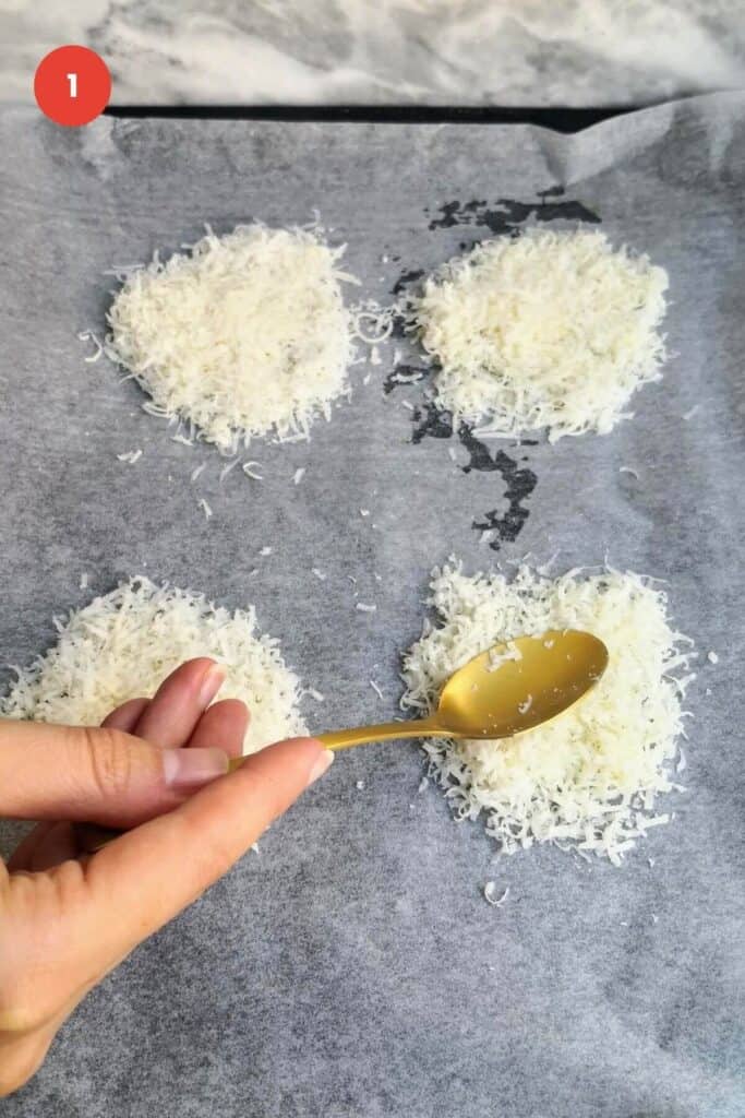 Spoon pressing down on parmesan cheese circles on baking pan.