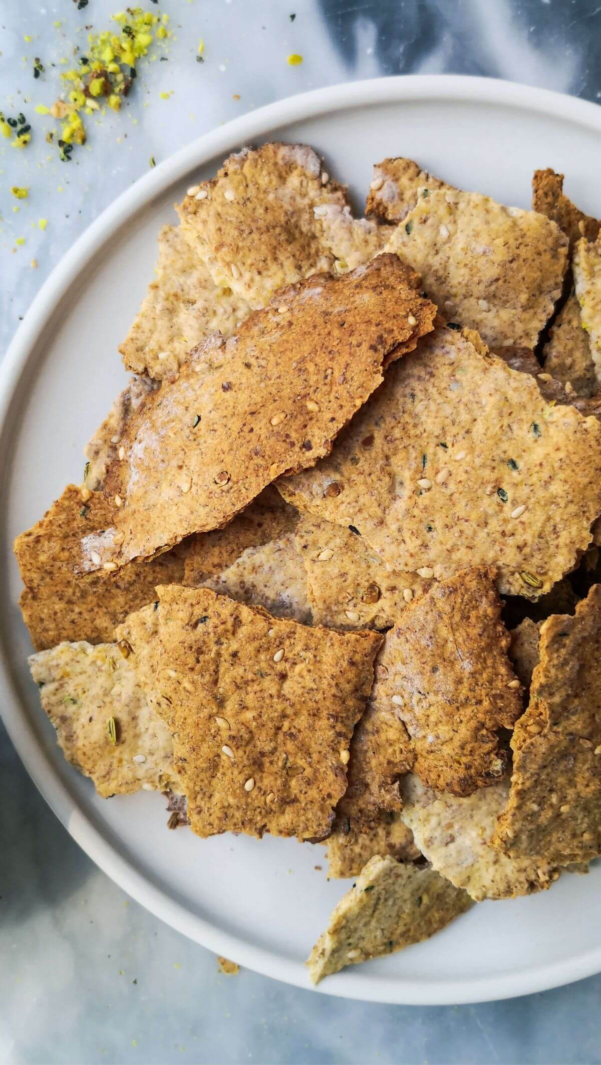 Sourdough crackers on a white plate with dukkah on the side.