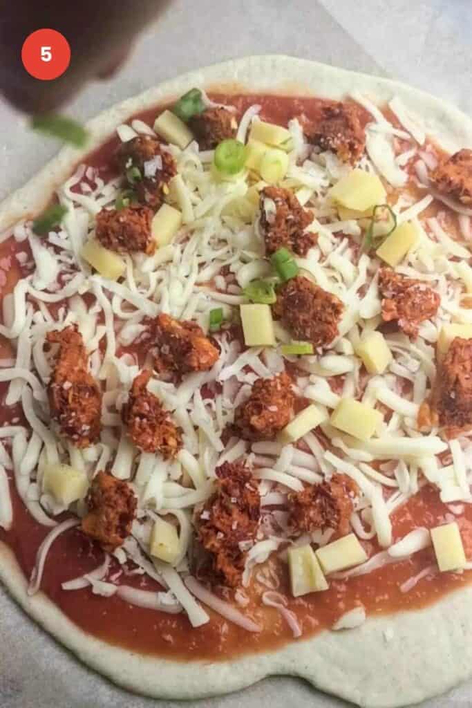 Pizza dough topped with cheese, nduja and scallions.