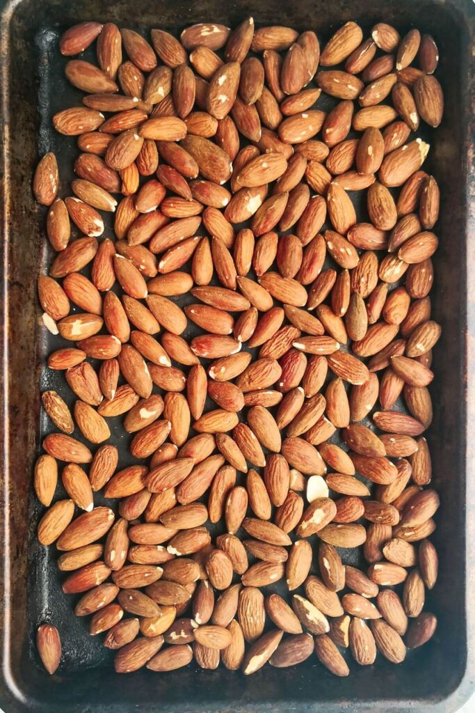 Roasted almonds laid out on an oven tray.