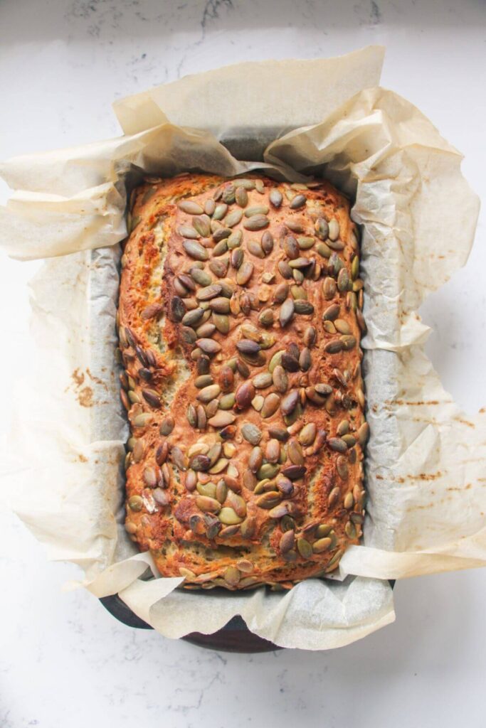 Seeded Vogels style bread in a baking paper lined tin.
