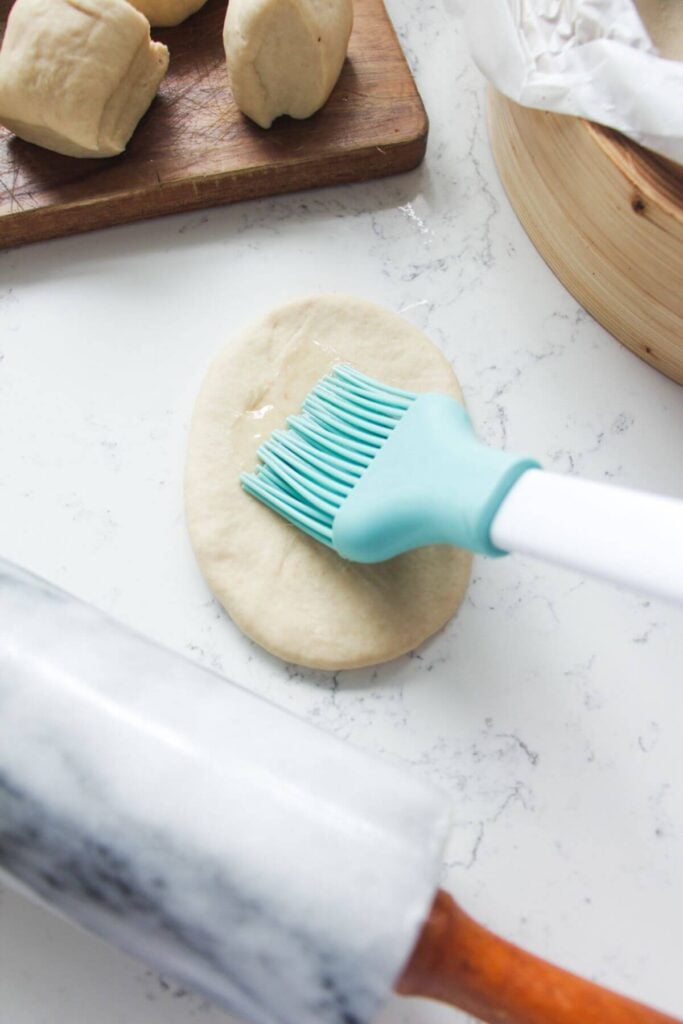 Brushing bao with oil.