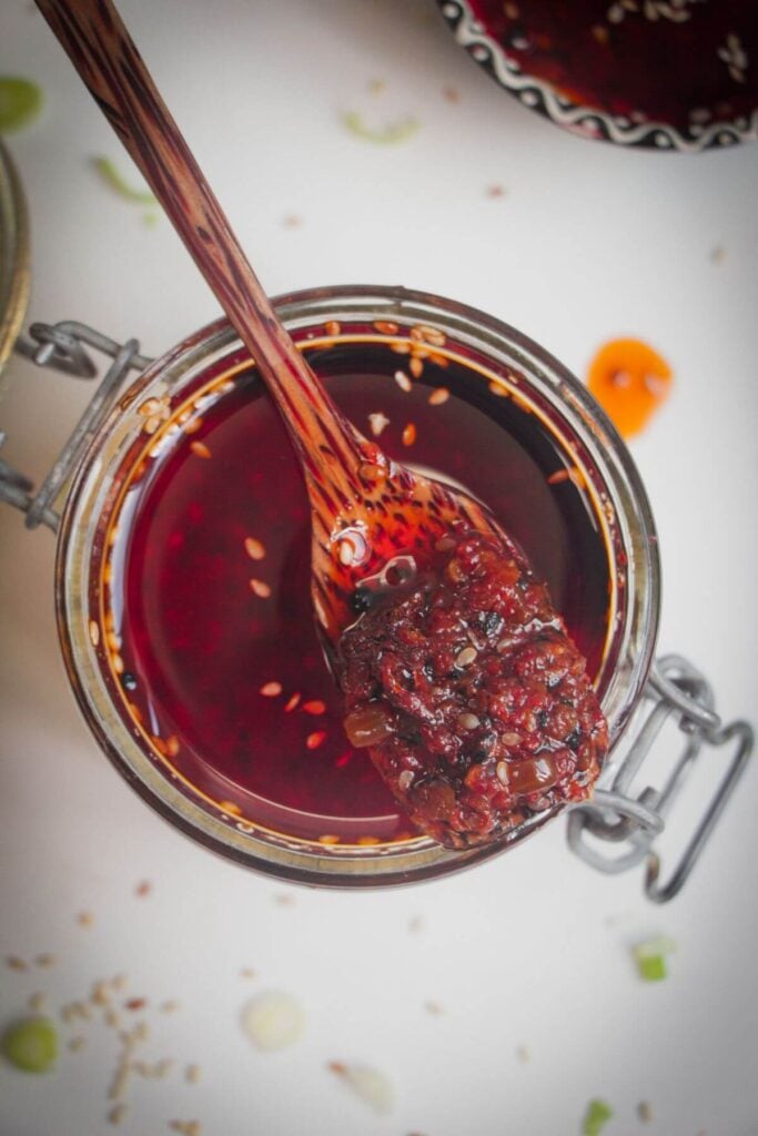 Wooden spoon in a jar of chilli oil.
