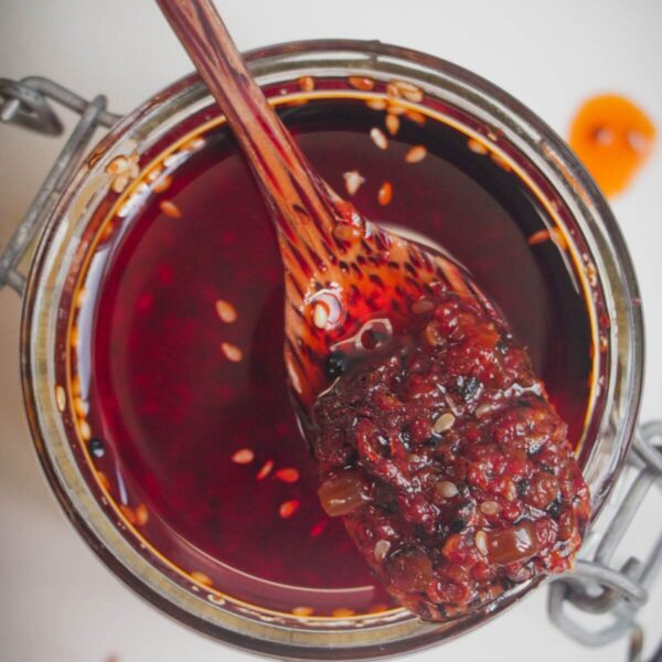 Wooden spoon in a jar of chilli oil.