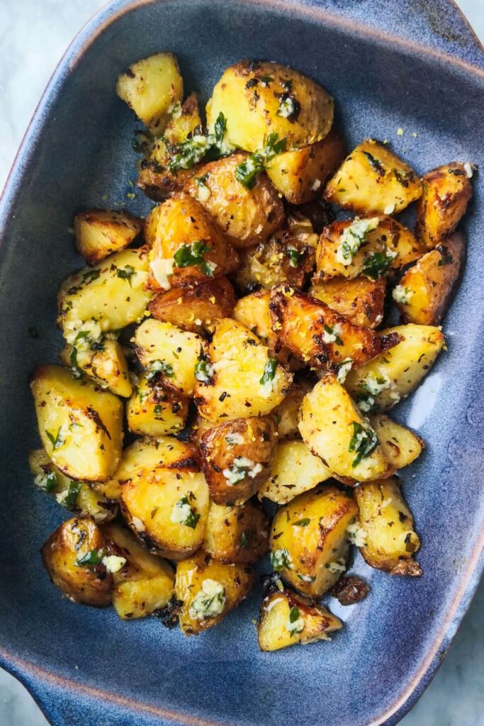 Garlic butter potatoes in a small blue oven dish.