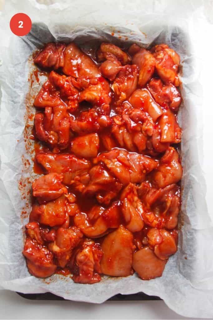 Gochujang marinated chicken arranged in oven tray.