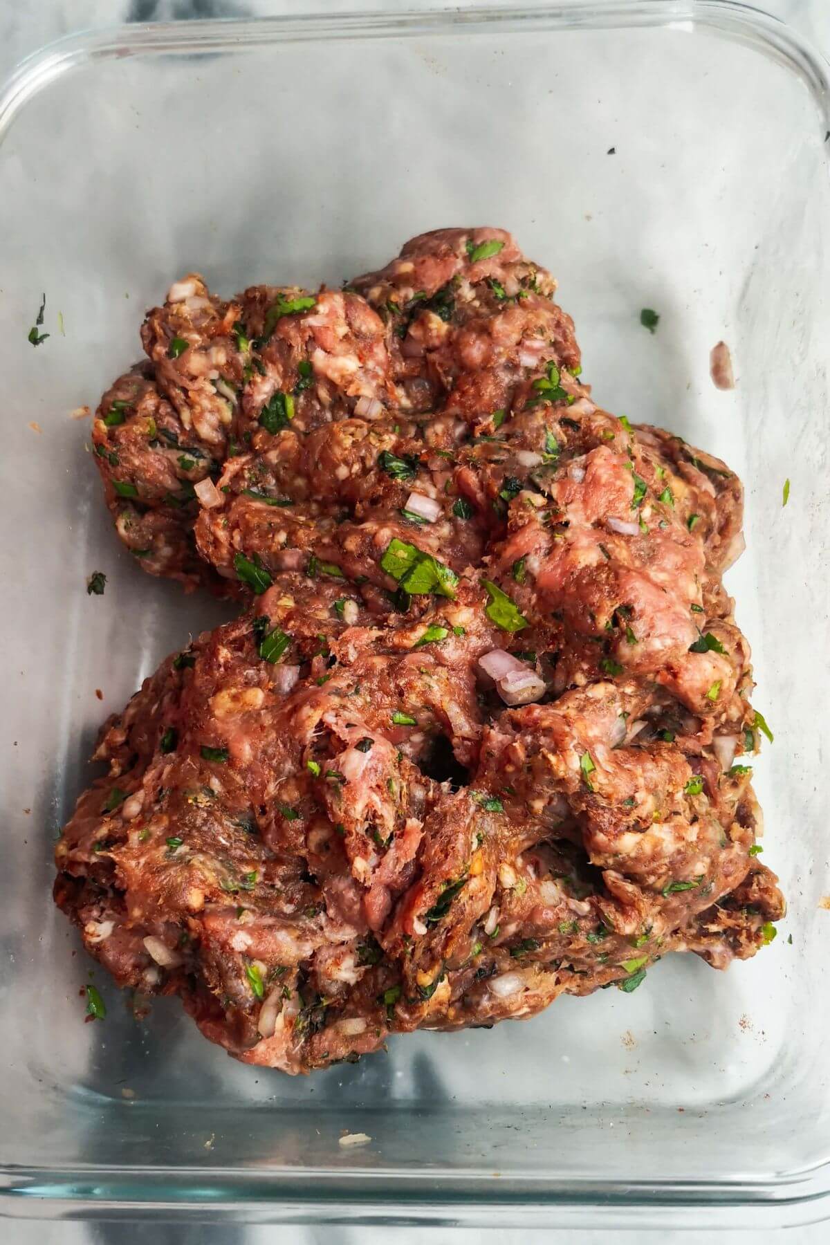 Lamb kofta mix all mixed together in a large glass container.