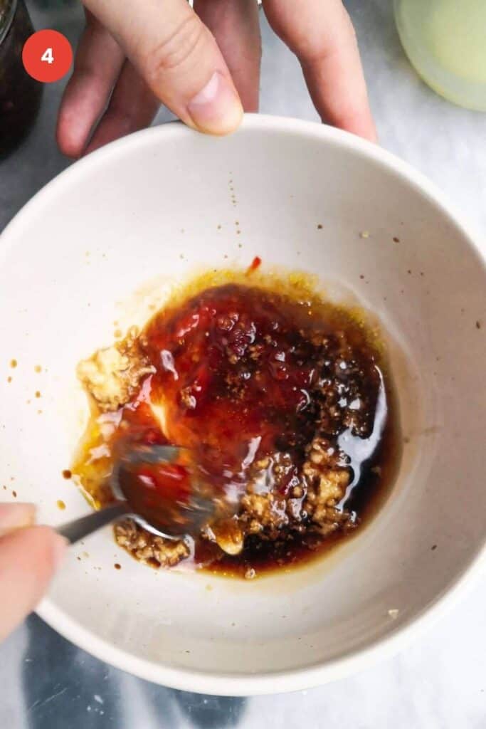 Mixing miso dressing in a bowl.