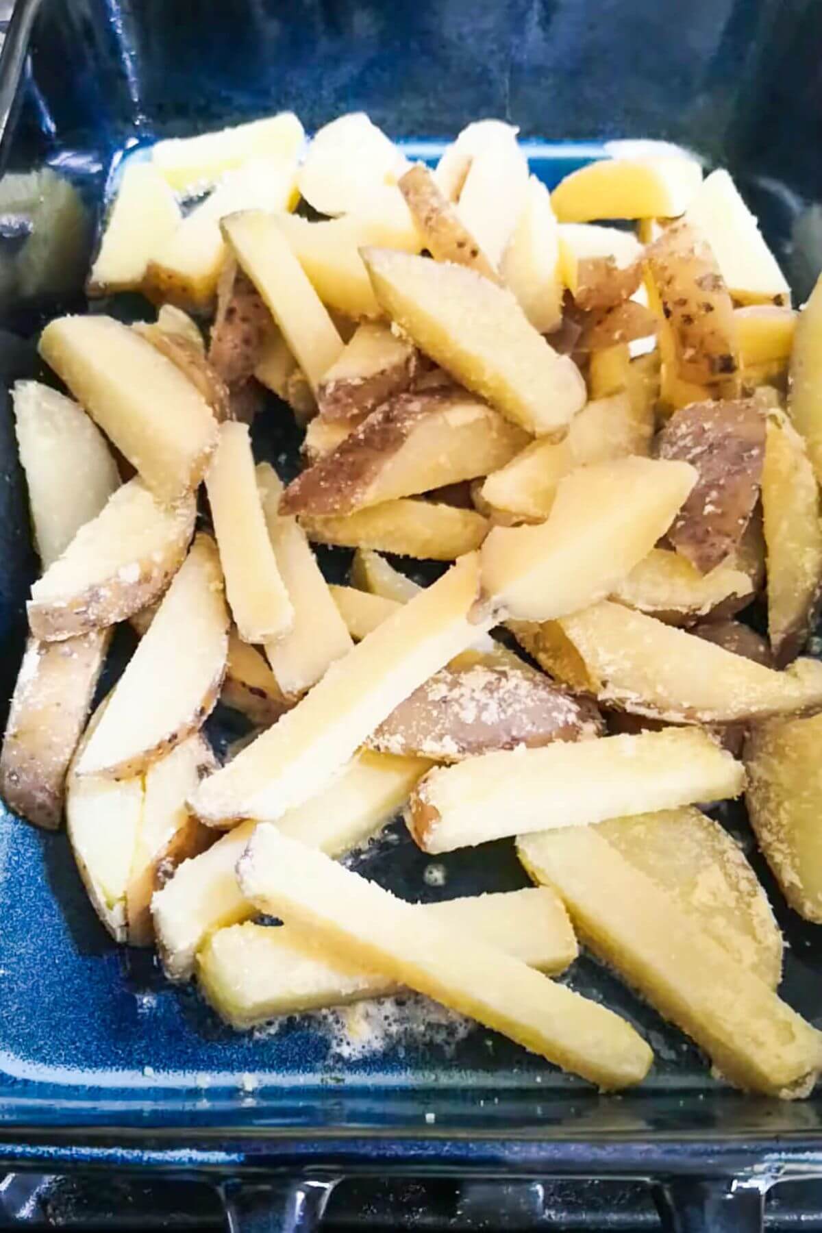 Polenta dusted chips in a large blue oven dish.