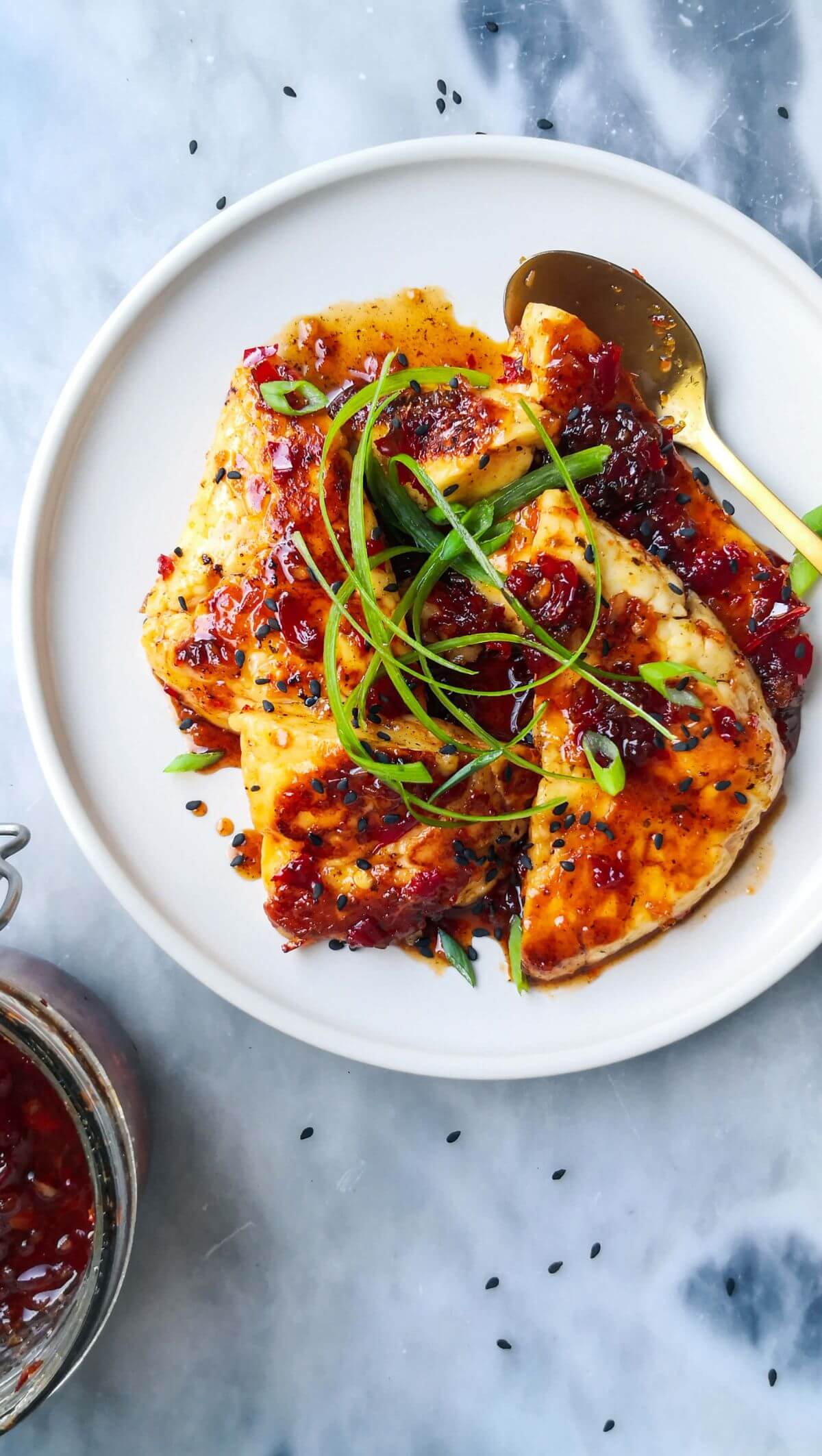 Sweet chilli glazed halloumi on a white plate with a gold spoon.