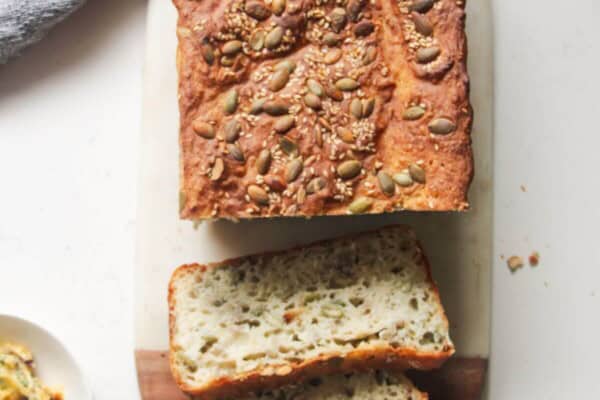 Vogel's style bread on a marble and wooden board, with 2 slices taken out of it.