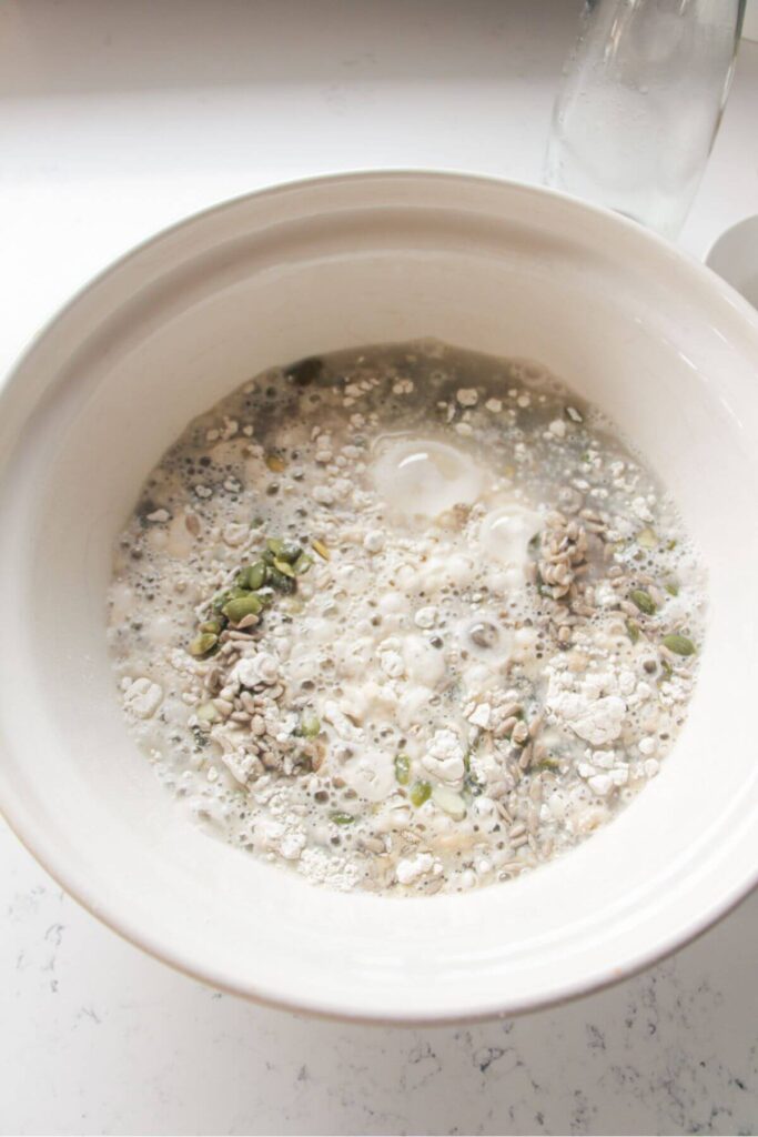 Water added to dry ingredients for Vogel's style bread in a large mixing bowl.