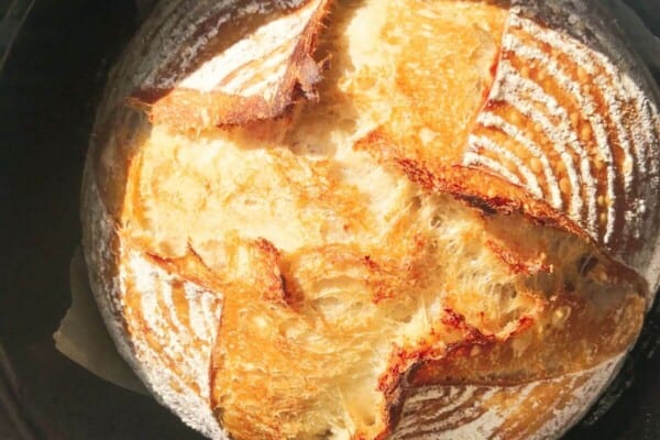 Golden baked bread in a black cast iron pot.