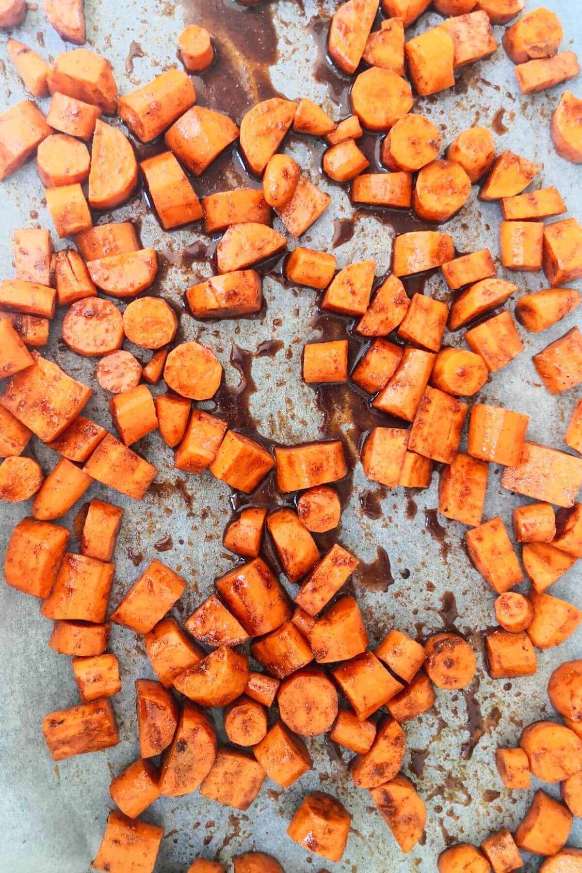 Chopped carrots laid out on a lined oven tray.
