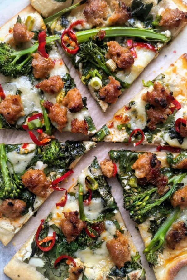 Whipped ricotta, sausage, broccolini and chilli pizza sliced.