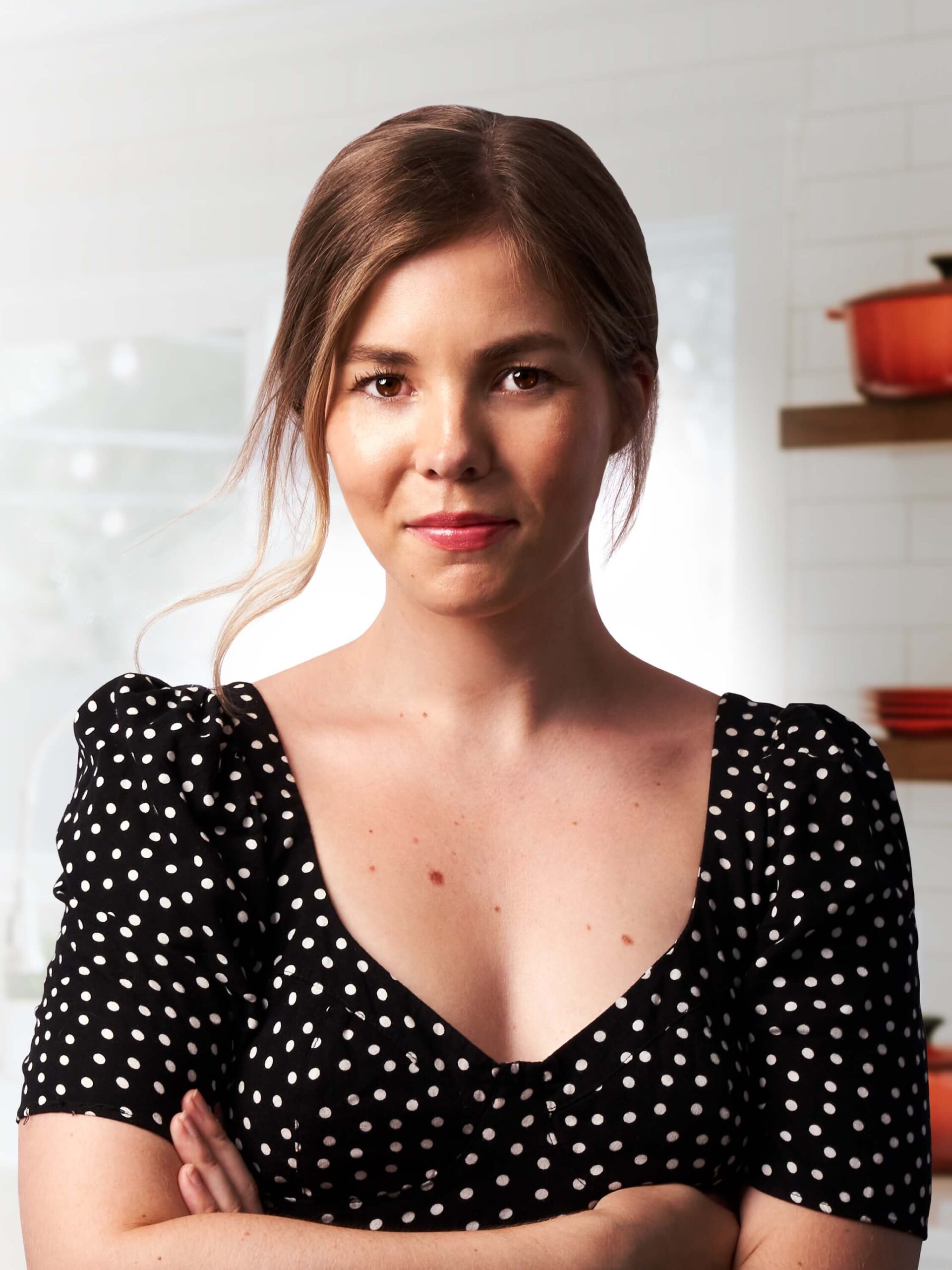 Kate with her arms folded in a white kitchen.