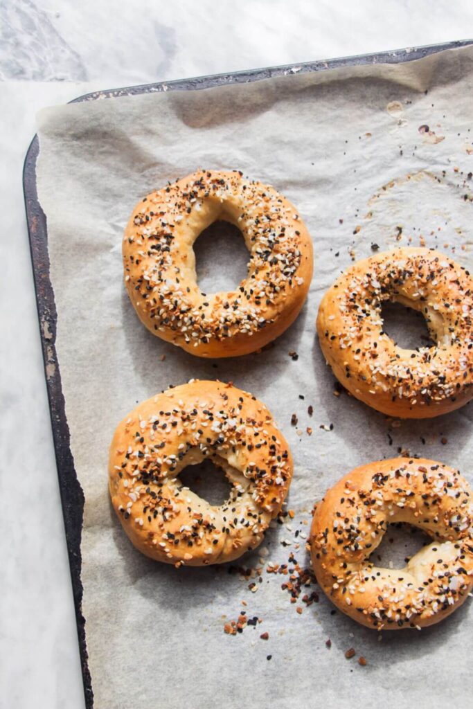 4 2 ingredient bagels after baking on a baking paper lined tray.