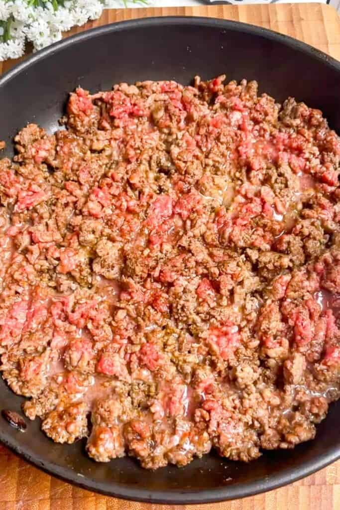 Ground beef browning in a pan.