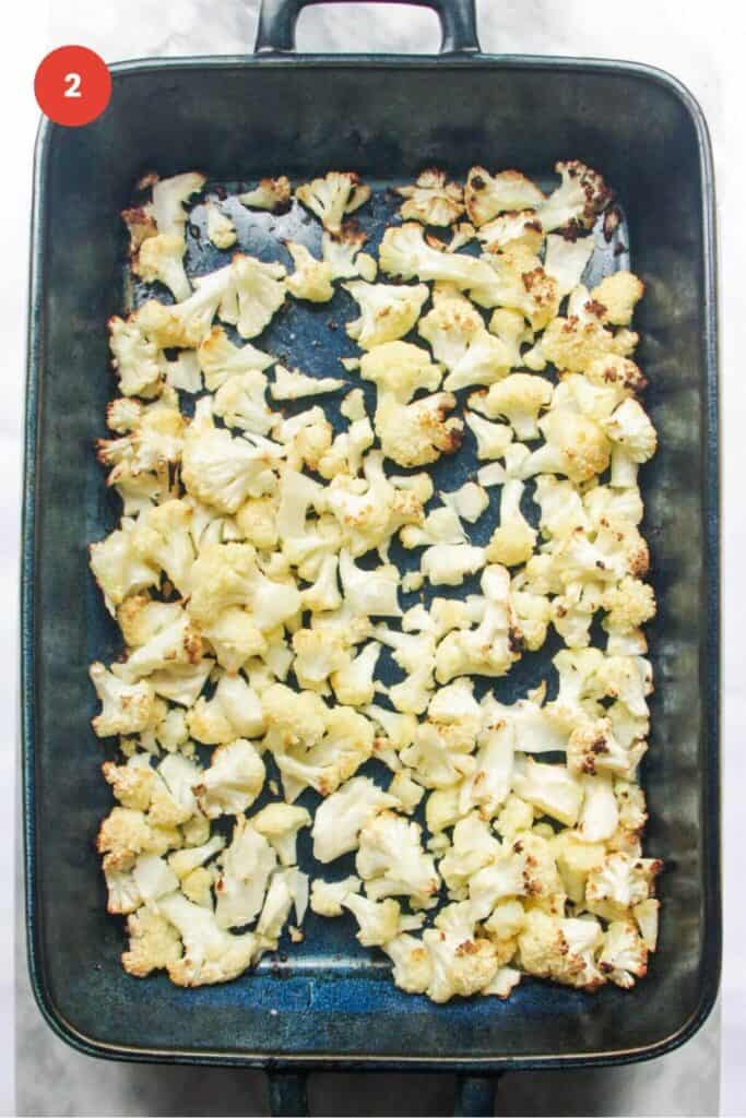 Roasted cauliflower florets in a baking dish.