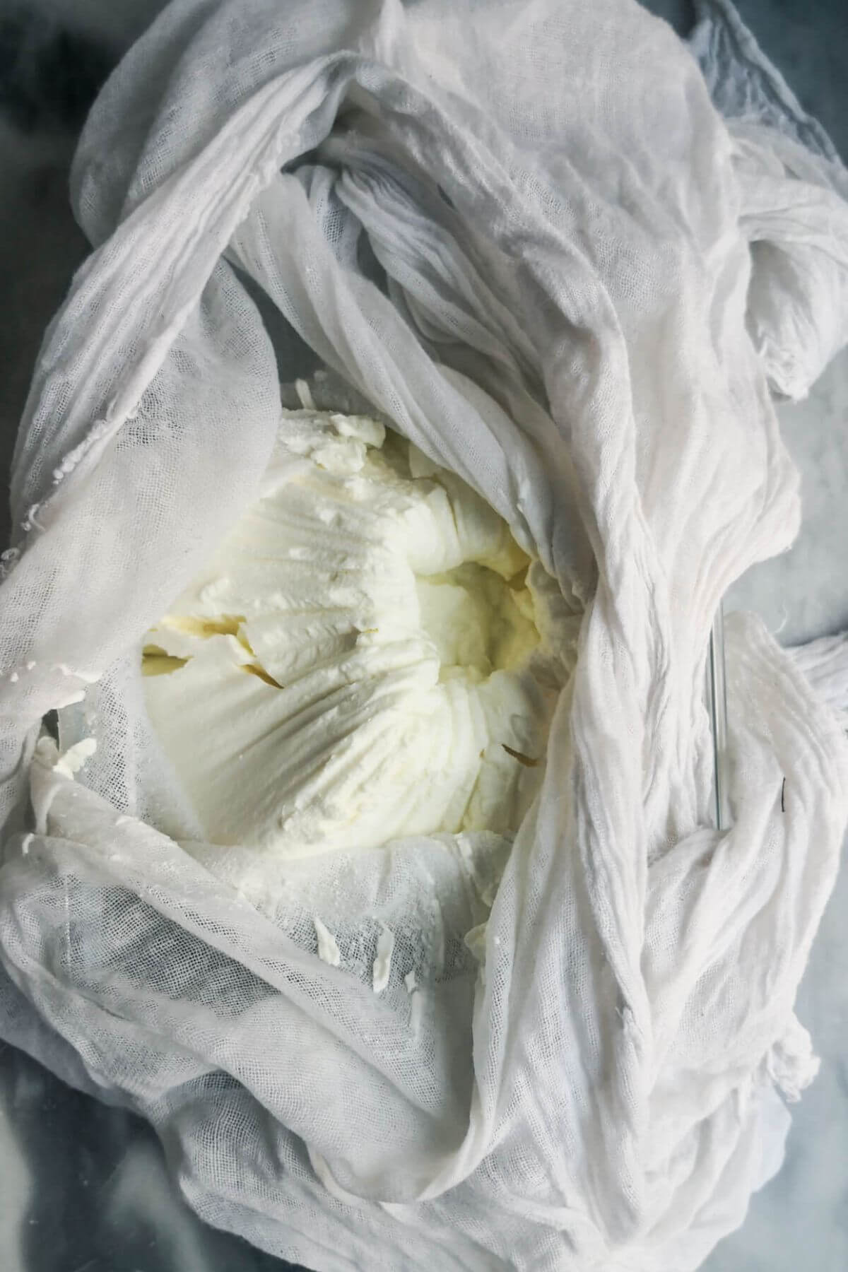 Strained labneh in a white cheesecloth.