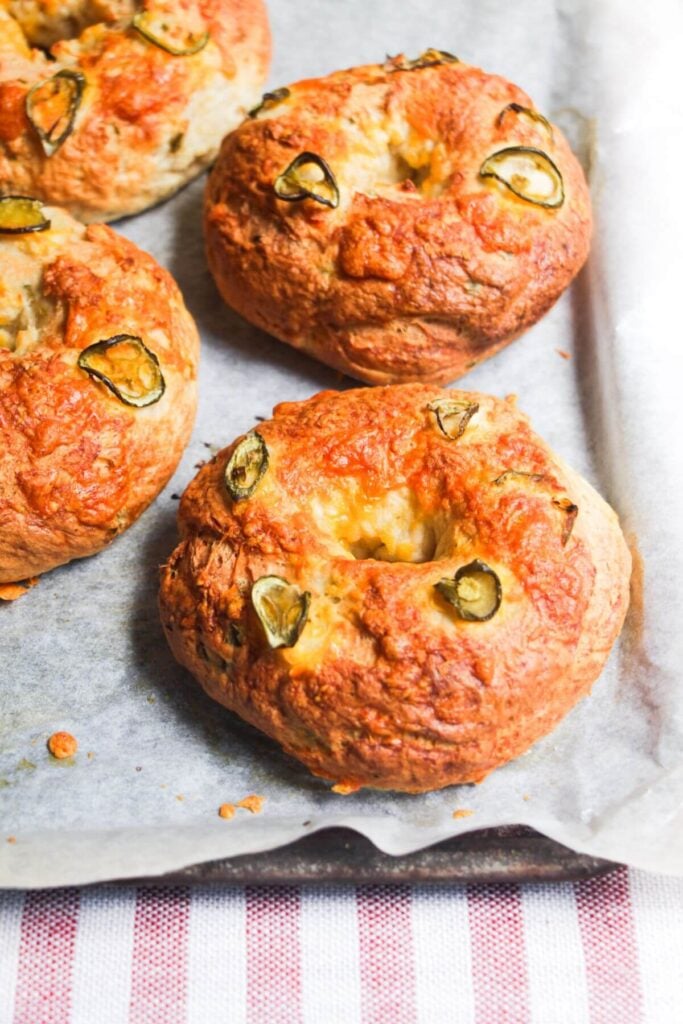 Cheese and jalapenos on top of bagels.