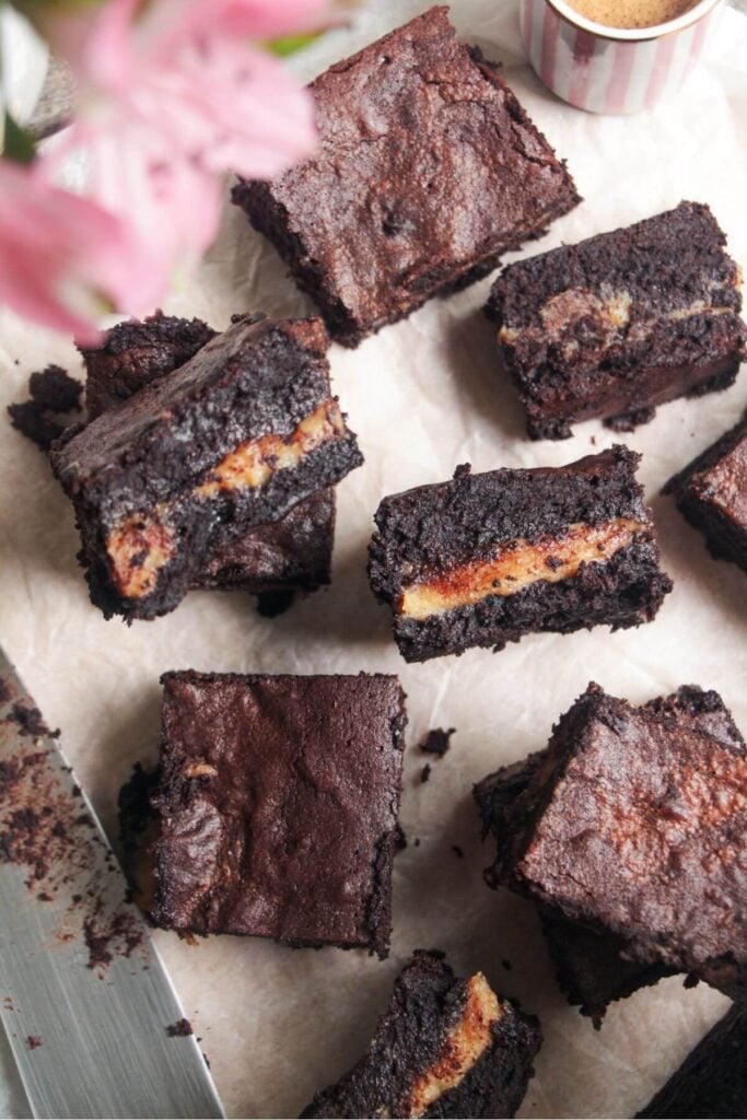 Sliced salted caramel brownies on baking paper.