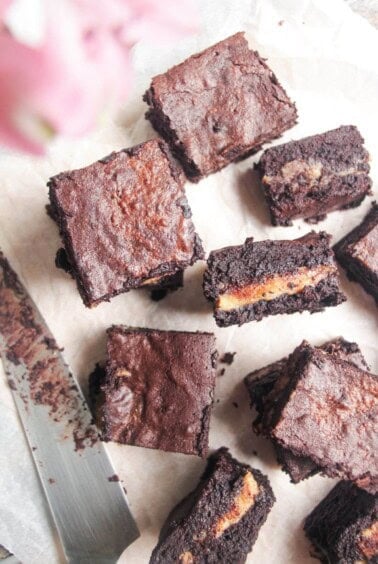 Sliced salted caramel brownies on baking paper.