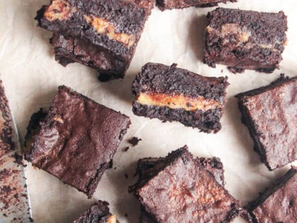 Sliced salted caramel brownies on baking paper.