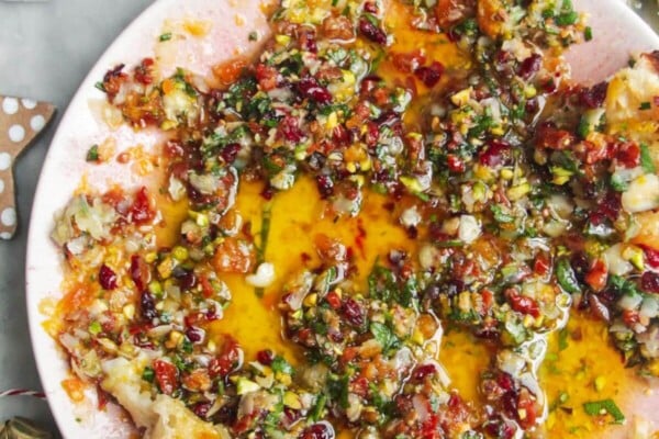 Festive dipping oil in a small pink plate on a grey surface.