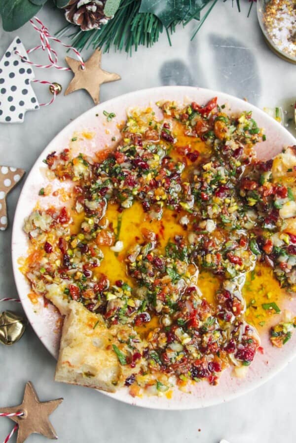 Festive dipping oil in a small pink plate on a grey surface.