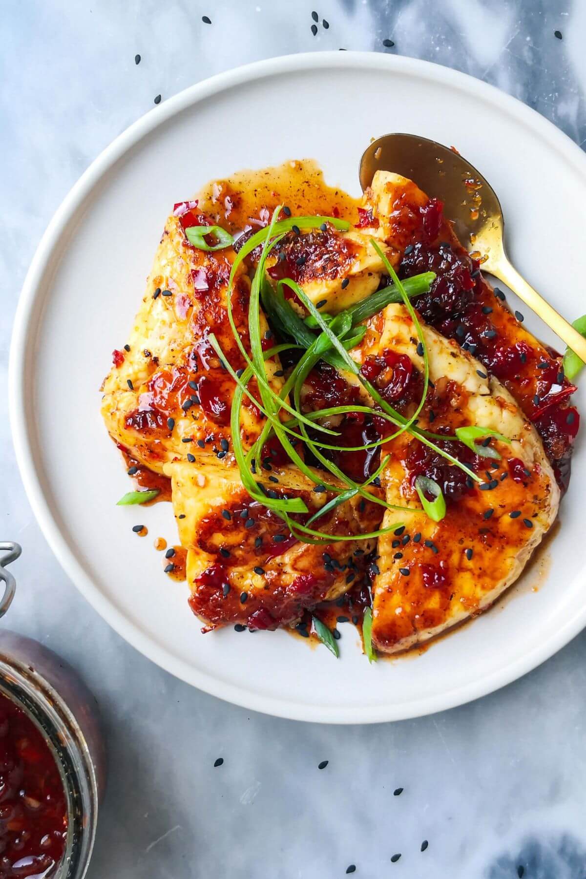 Sweet chilli glazed halloumi on a white plate with a gold spoon.