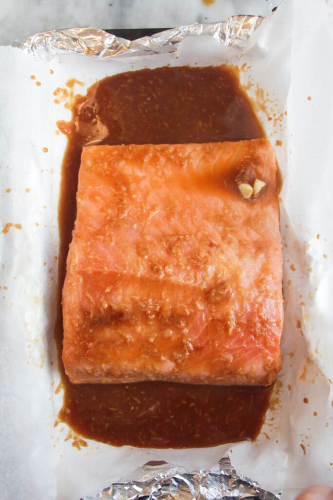 Maple miso glazed salmon fillet baked in a lined oven tray.