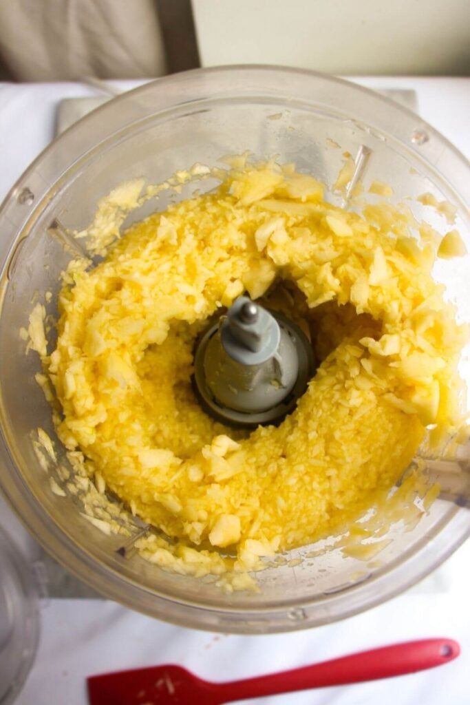 Blitzed up apples in the bowl of a food processor.