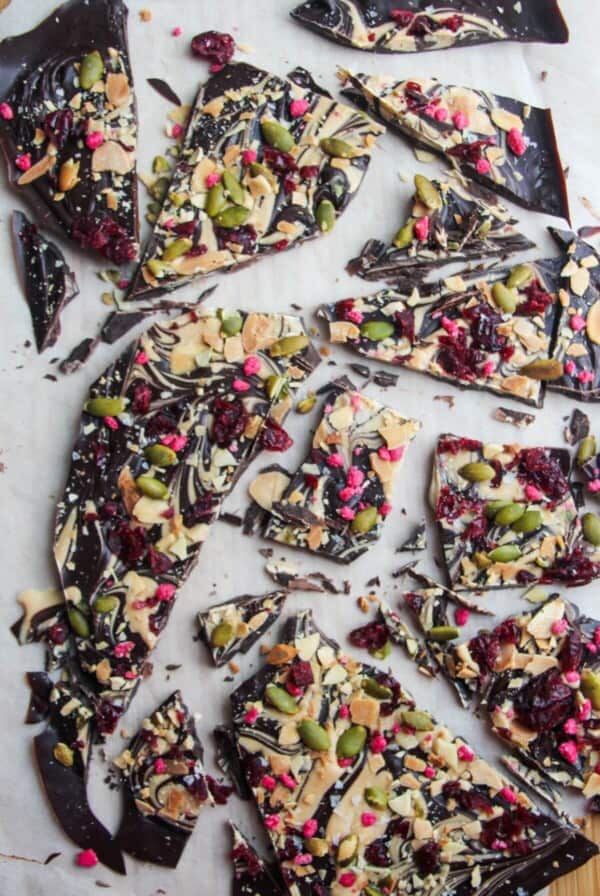 Chocolate almond bark broken into shards on a wooden board.