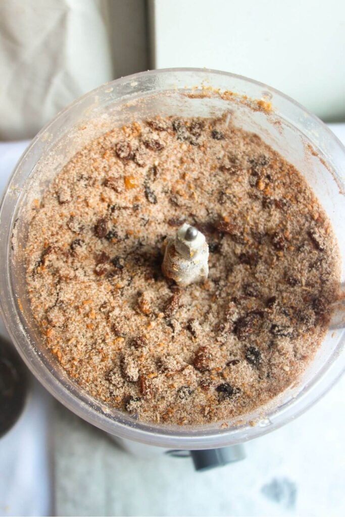 Dried fruit and sugar in the bowl of a food processor.