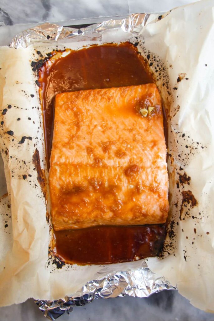 Maple miso salmon fillet grilled on a baking paper lined tray.