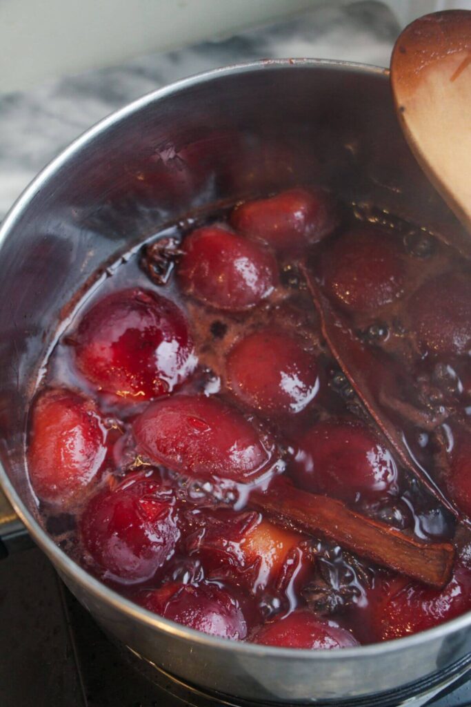 Sticky plum sauce cooked in a small silver pan.