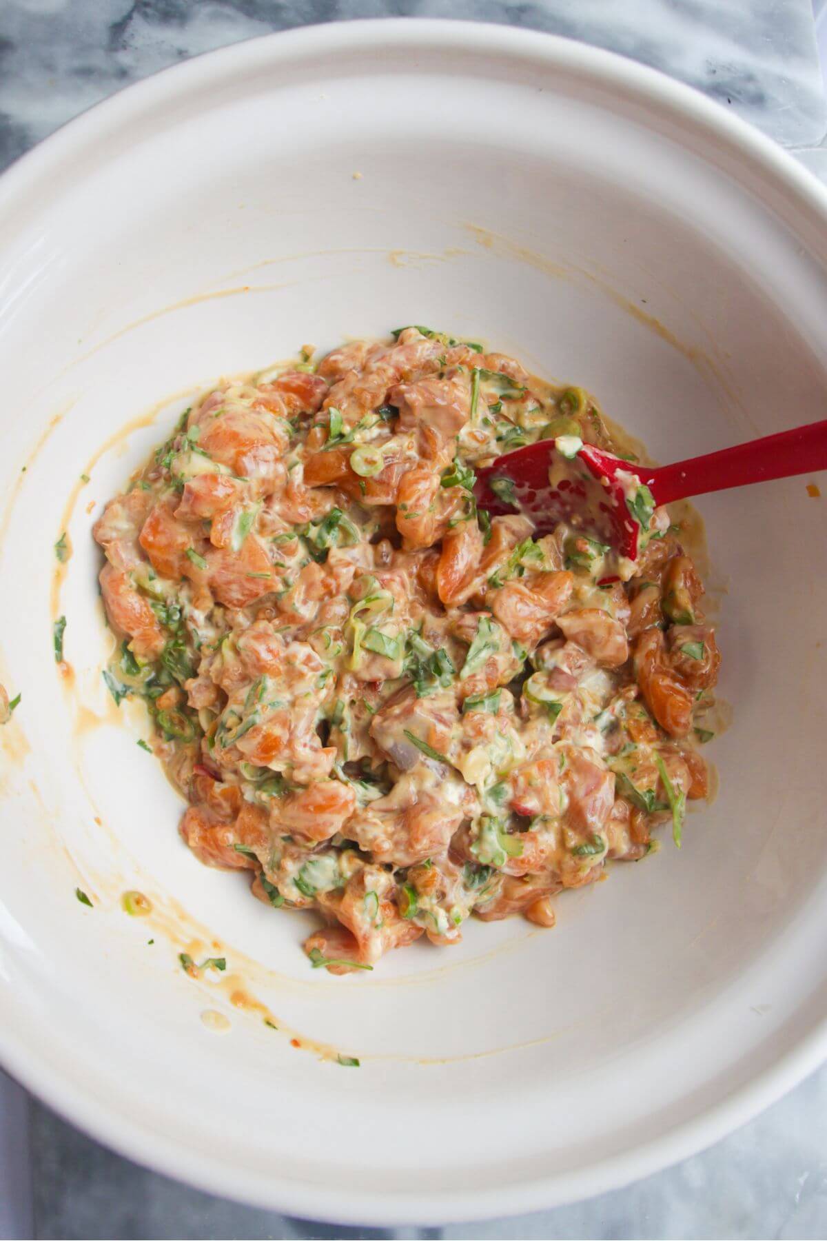 Salmon sushi mix in a large white mixing bowl.