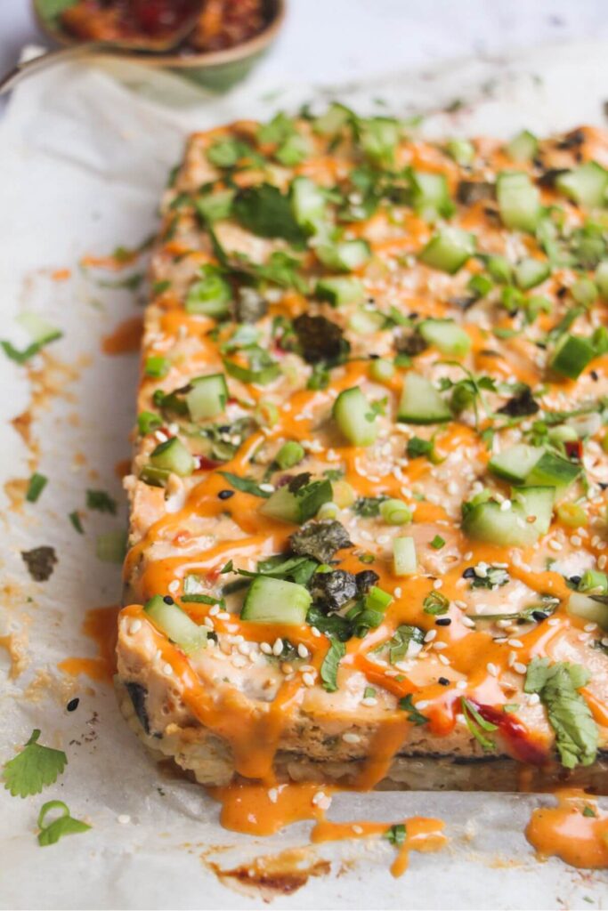 Salmon sushi bake topped with diced cucumber, spring onion, spicy mayo.