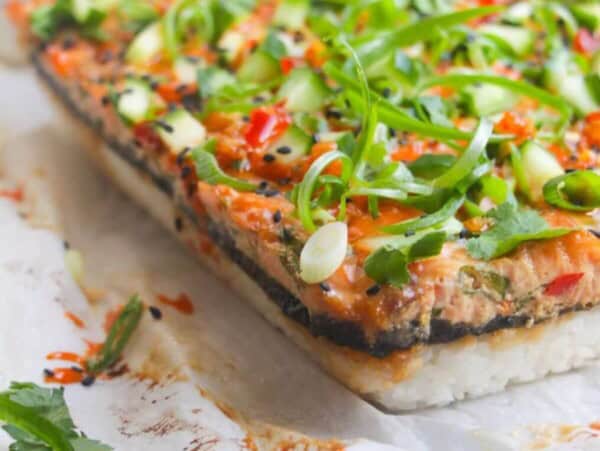 Salmon sushi bake on a baking paper lined tray.