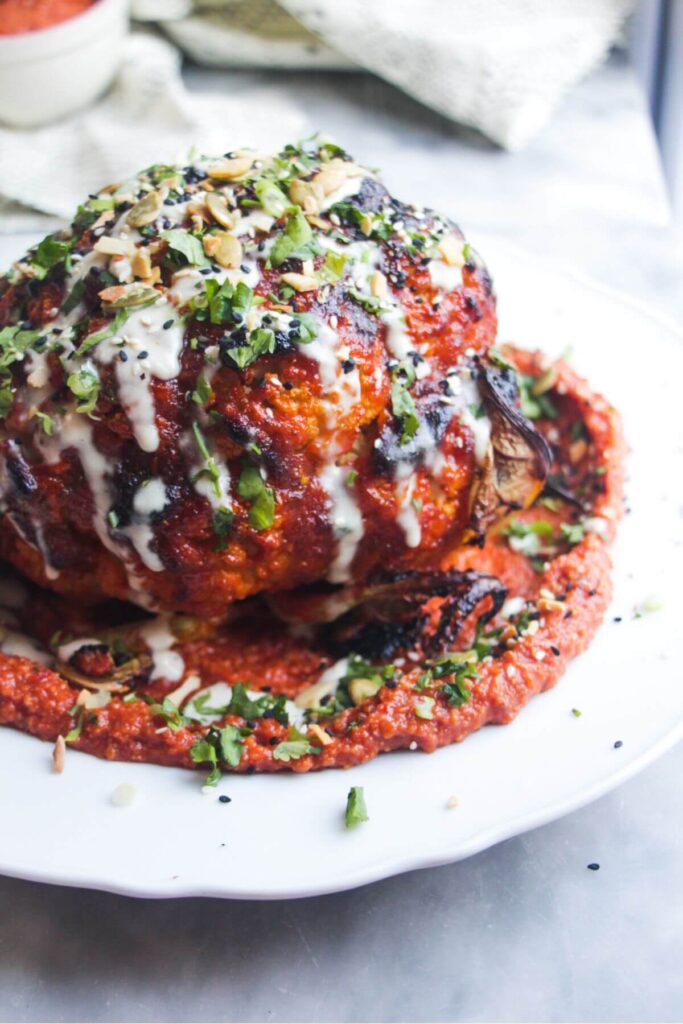 Whole roasted cauliflower topped with sesame seeds, coriander, spring onions and tahini.