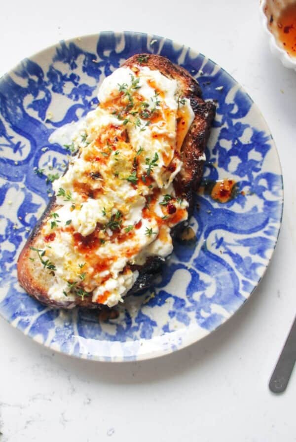 Burrata on a piece of toasted sourdough with hot honey and thyme on top.