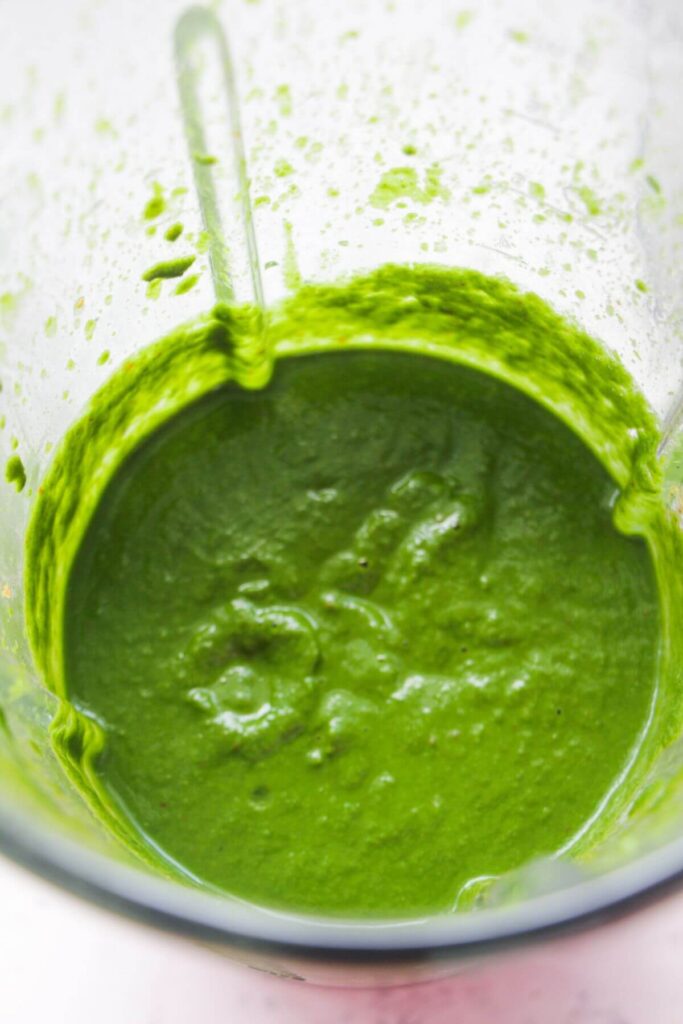 Bright green saag sauce blitzed up in a blender.