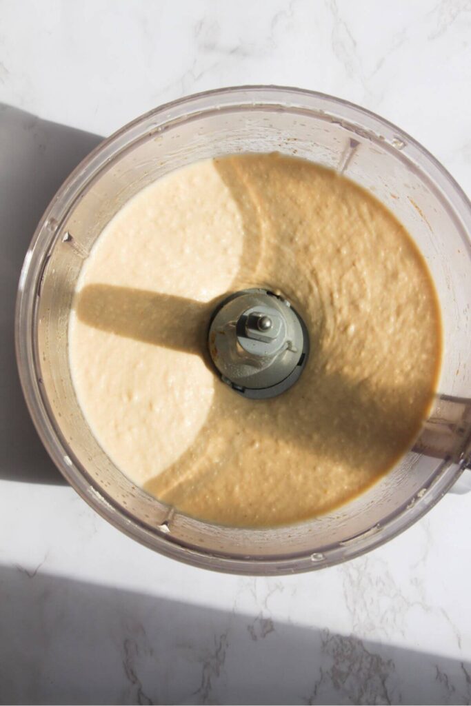 Blended white bean dip in the bowl of a food processor.