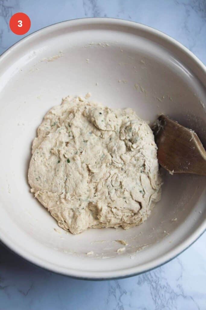 Rosemary parmesan bread dough in bowl.